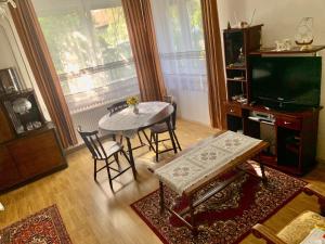 uma sala de estar com uma mesa e cadeiras e uma televisão em Grany's Retro Guesthouse near Budapest AirPort em Vecsés