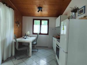 a kitchen with a white table and a refrigerator at Dragana in Basina
