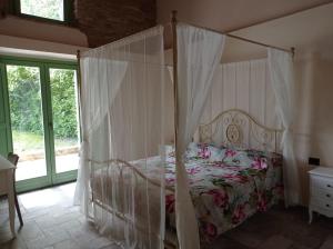 a bedroom with a bed with a canopy at Villa Incanto in Apiro