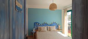 1 dormitorio con 1 cama con pared azul en Casa Luz, en Yaiza