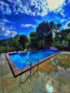 a large swimming pool with a blue sky in the background at Chalona Hill View in Munnar