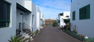 an alley between two white buildings with plants at Casa Luz in Yaiza