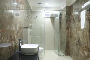 a bathroom with a shower and a toilet and a sink at Pt Moolraj Residency in Una +35 photos