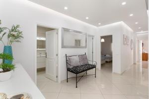 a living room with a chair and a hallway at Zurrinha holidays in Quarteira
