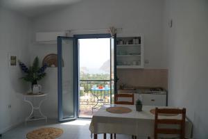 a kitchen with a table and a door leading to a balcony at Taxiarchis in Symi