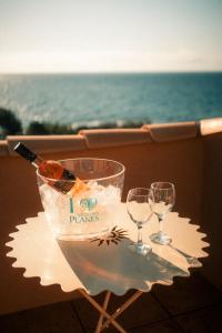 un tavolo con due bicchieri di vino e una bottiglia di Hôtel Les Calanques a Les Issambres