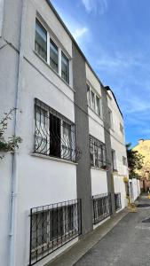a white building with barred windows on a street at KELES HOME in Trabzon