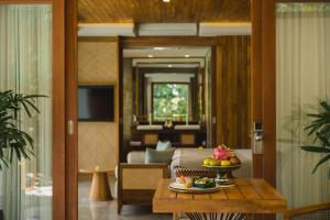 乌布Suweta Villa Ubud的客厅里设有一张桌子,上面放着一碗水果