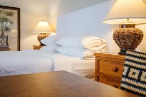 a bedroom with two beds and a table with a lamp at Wine & Roses Hotel Restaurant Spa Lodi in Lodi