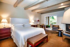 a bedroom with a large white bed and a fireplace at Wine & Roses Hotel Restaurant Spa Lodi in Lodi
