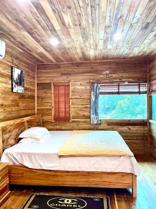 una camera con un letto in una cabina di legno di Cat Ba Love House a Cat Ba