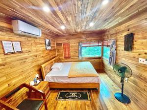 ein Schlafzimmer mit einem Bett in einer Holzhütte in der Unterkunft Cat Ba Love House in Cát Bà