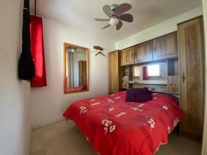 1 dormitorio con cama roja y ventilador de techo en Sol-y-Days Californie, Appartement confortable 4 personnes à 300m de la plage, en Le Grau-du-Roi