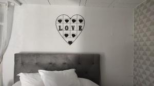 un panneau cardiaque sur un mur au-dessus d'un lit dans l'établissement Enjoy, à Le Tampon
