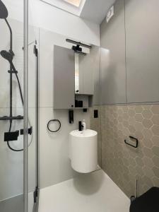 un bagno bianco con lavandino e doccia di Tymiankowa Przystań a Ełk Altre 32 foto