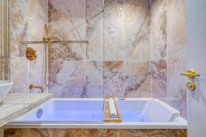 La salle de bains est pourvue d'une baignoire et d'un lavabo. dans l'établissement Melody suite in Paris, à Courbevoie