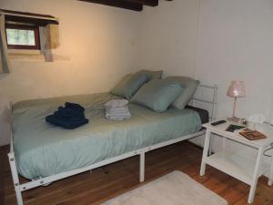 Bett in einem Zimmer mit einem Tisch und einer Lampe in der Unterkunft Rêves et Chaudrons in Vicq-Exemplet