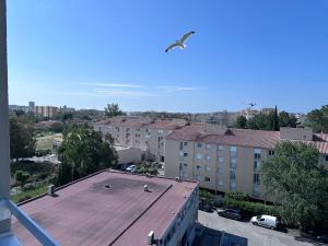 um pássaro a voar sobre um telhado numa cidade em Ibis Budget Fréjus St Raphaël centre et plages à 900m em Fréjus