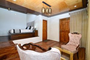 a bedroom with a bed and a couch and a chair at Thiksay Organic Resort in Ranbirpura