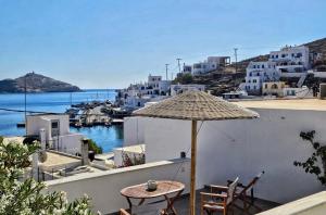 a patio with a table and an umbrella at Sea-View Rooftop Terrace Studio in Panormos