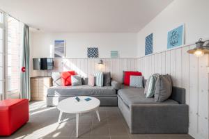 ein Wohnzimmer mit einem Sofa und einem Tisch in der Unterkunft Pierre & Vacances Premium Résidence de la Plage in Le Crotoy