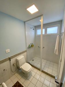 un bagno bianco con wc e doccia di Búzios Beach Resort - Apartamento a Búzios