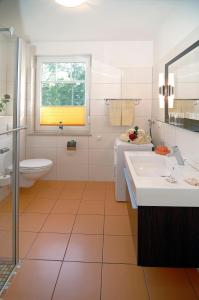 a bathroom with two sinks and a toilet at Appartementhaus Ostseeresidenz in Warnemünde