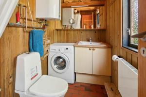 W łazience znajduje się pralka i umywalka. w obiekcie Idyllic Coastal Cottage Modern Comfort w mieście Kalundborg