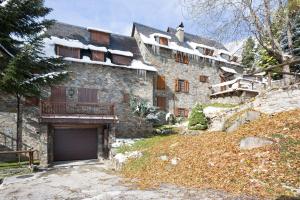 uma grande casa de pedra com garagem no quintal em Luderna - Casa con terraza Cuylas em Baqueira-Beret