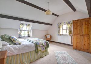 ein Schlafzimmer mit einem Bett und zwei Fenstern in der Unterkunft Hendy in Gwaynynog