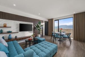 a living room with a blue couch and a table at ViAn Hotel And Spa Danang in Da Nang