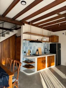 a kitchen with wooden cabinets and a black refrigerator at Makai Medewi in Airsatang +37 photos