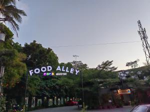 un letrero de un callejón de comida al lado de una calle en Containers by Eco Hotel, en Tagaytay