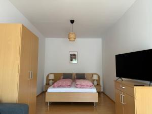 a bedroom with a bed and a flat screen tv at Lindenhof Deutsch in Bad Tatzmannsdorf