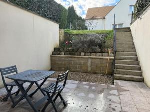 a table and two chairs sitting next to a wall at Joli Studio au calme mais proche gare et bus in Luzarches