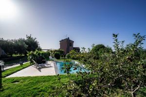 a pool in a yard with a church in the background at Nake Residenza Artistica in SantʼAlfio