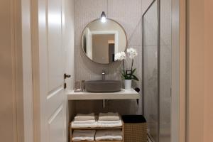 un bagno con lavandino e specchio di Aledo Boutique Apartments a Napoli