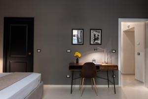 - une chambre avec un lit et un bureau avec une lampe dans l'établissement Aledo Boutique Apartments, à Naples
