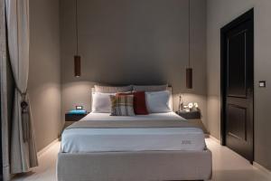 - une chambre avec un grand lit et des oreillers dans l'établissement Aledo Boutique Apartments, à Naples