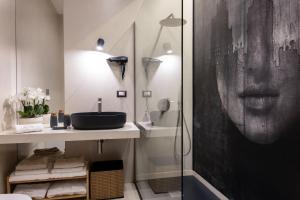 un bagno con lavandino e doccia di Aledo Boutique Apartments a Napoli
