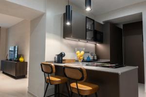 una cucina con bancone e due sedie al bar di Aledo Boutique Apartments a Napoli Altre 23 foto