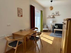 salon z drewnianym stołem i krzesłami w obiekcie Lindenhof Deutsch w mieście Bad Tatzmannsdorf