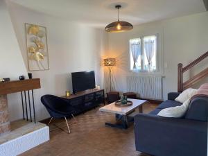 ein Wohnzimmer mit einem Sofa und einem TV in der Unterkunft Chez Tad Kozh Maison familiale in Paimpol