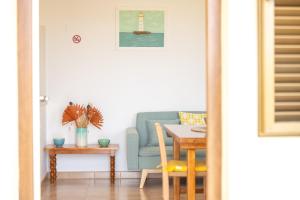 un salon avec un canapé bleu et un phare dans l'établissement Apartamentos Verde Mar, à Es Pujols