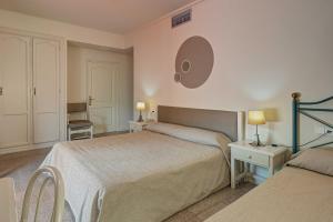 a bedroom with two beds and a mirror on the wall at Hotel Castell Blanc in Empuriabrava +111 photos