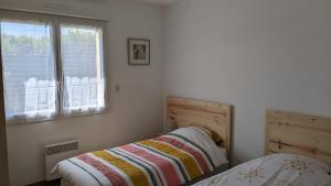 a bedroom with two beds and a window at Un tour dans la Manche - A 500 m de la plage in Portbail