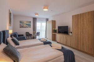 Habitación de hotel con 2 camas y TV de pantalla plana. en Srebrna Wydma Resort en Dąbki