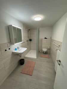 a bathroom with a sink and a shower and a toilet at Ferienhaus Am Südwall, 220qm in Medebach