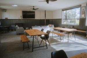 a room with tables and chairs and a tv at Tiny House 18 at Grampians Edge in Dadswells Bridge