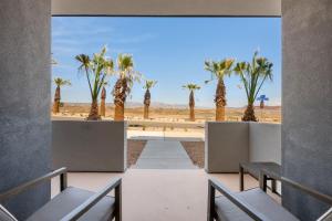 uitzicht op het strand vanuit een kamer met banken en palmbomen bij Blue Sky Oasis condo in St. George